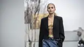 Mujer con top colorido y blazer negro. 