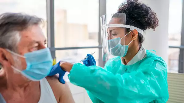 enfermera aplicando vacuna a adulto