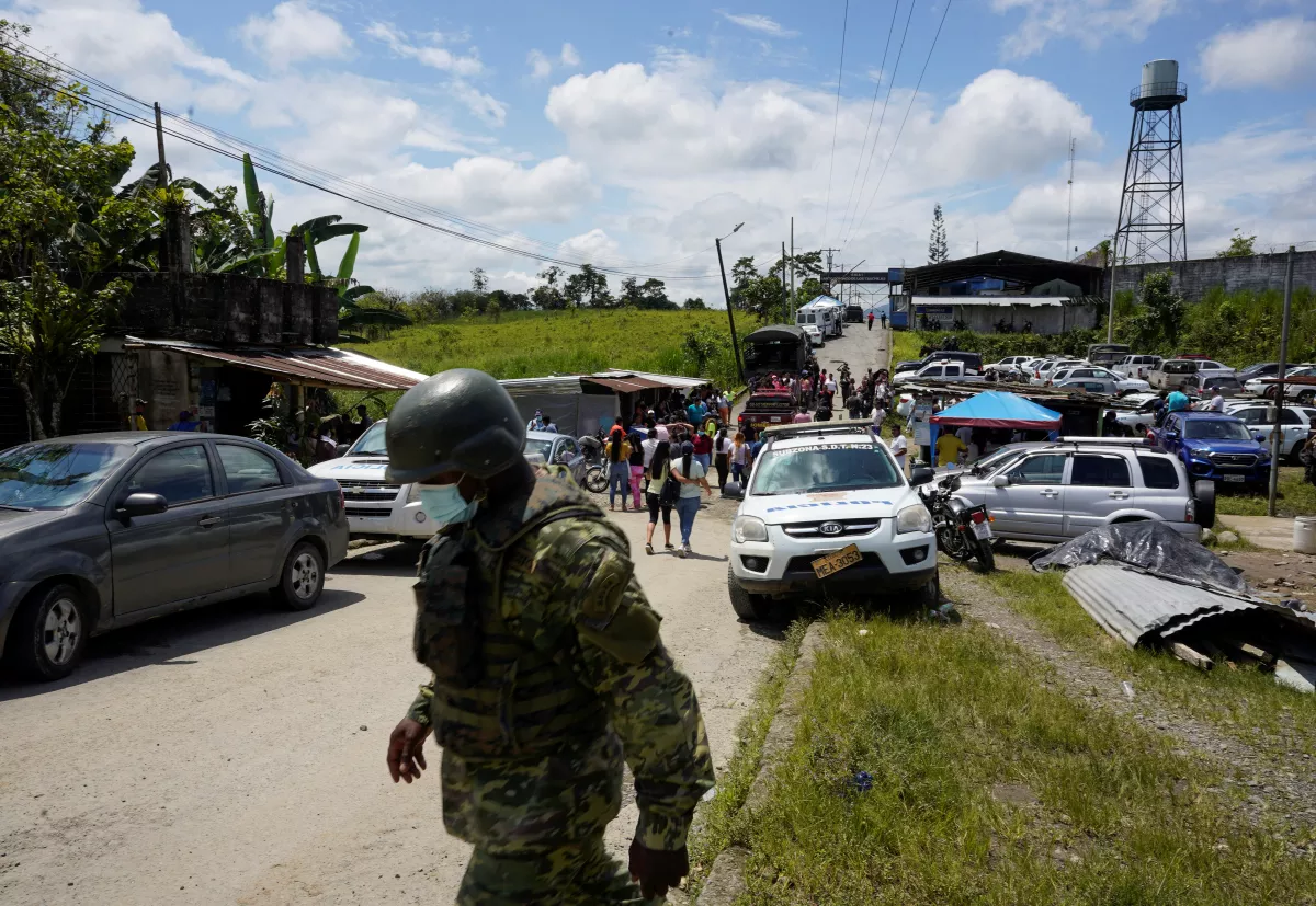 Un soldado cruza la calle mientras los miembros de las familias de los internos esperan afuera de prisión de Santo Domingo de los Tsáchilas en el centro de Ecuador. 