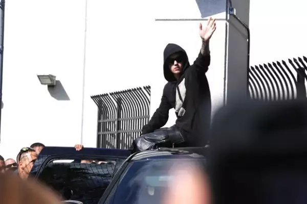 Como si presumiera un triunfo, Bieber saludó a la gente que aguardaba su salida de la prisión.