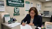 Mujer de 50 años firma su contrato de la Modalidad 40 del IMSS.