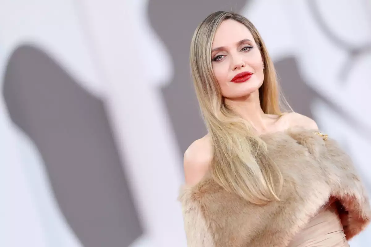 Foto de Angelina Jolie durante la alfombra roja de la película 'Maria', en el Festival Internacional de Cine de Venecia 2024. Lleva el cabello rubio, largo y los labios rojos.