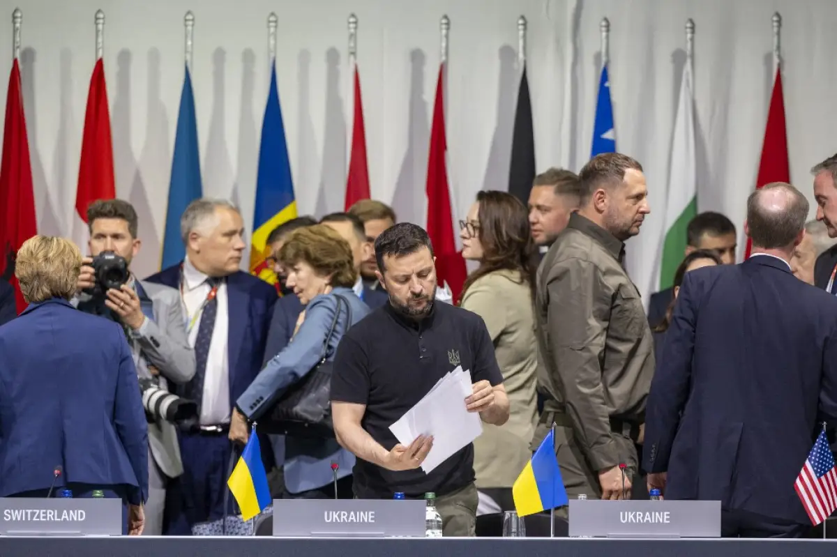 El presidente de Ucrania, Volodymyr Zelensky (C), mira los documentos mientras asiste a una sesión plenaria en la Cumbre sobre la paz en Ucrania, en el complejo de lujo de Burgenstock, cerca de Lucerna, el 16 de junio de 2024. La reunión de dos días reúne al presidente ucraniano y a más de otros 50 jefes de estado y de gobierno, para tratar de entrar un camino hacia un proceso de paz para Ucrania, aunque sin Rusia.