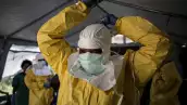 Una trabajadora médica se pone su Equipo de Protección Personal (EPP) antes de entrar en un Centro de Tratamiento del Ébola dirigido por la Alianza para la Acción Médica Internacional (ALIMA) el 12 de agosto de 2018, en Beni.