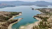 Un cuerpo de agua de diferentes tonalidades de azul en medio de zonas semiáridas y montañas con cielo azul.jpg
