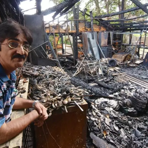 Azim Mohamed observa los restos de su negocio quemado
