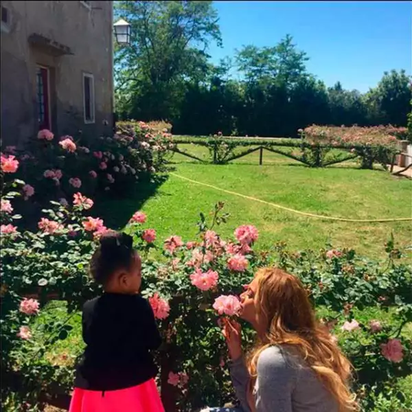 Mamá e hija disfrutan de las cosas simples de la vida. Aquí las vemos admirar la belleza y disfrutar el aroma de una rosa.