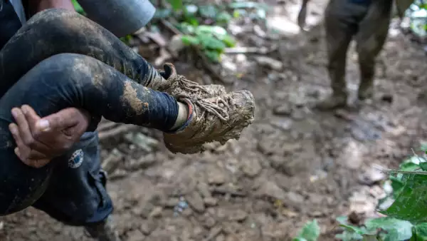 Un guía colombiano lleva a un niño haitiano por una ladera de una montaña cerca de la frontera de Colombia con Panamá el 19 de octubre de 2021 en Darien Gap, Colombia. La caminata de 66 millas a través de la densa selva tropical y las montañas se considera el tramo más difícil para los migrantes que viajan de América del Sur a los Estados Unidos.
