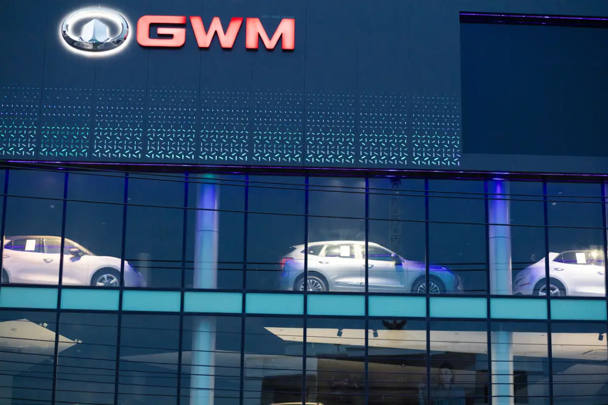 Un logo de GWM en color rojo luce en la fachada de un concesionario de la marca.
