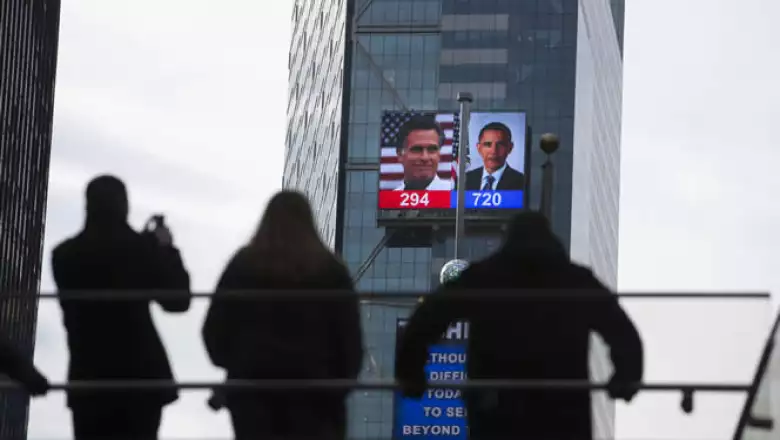 La gente ve la cobertura electoral en una pantalla gigante instalado en Times Square durante la elección presidencia.