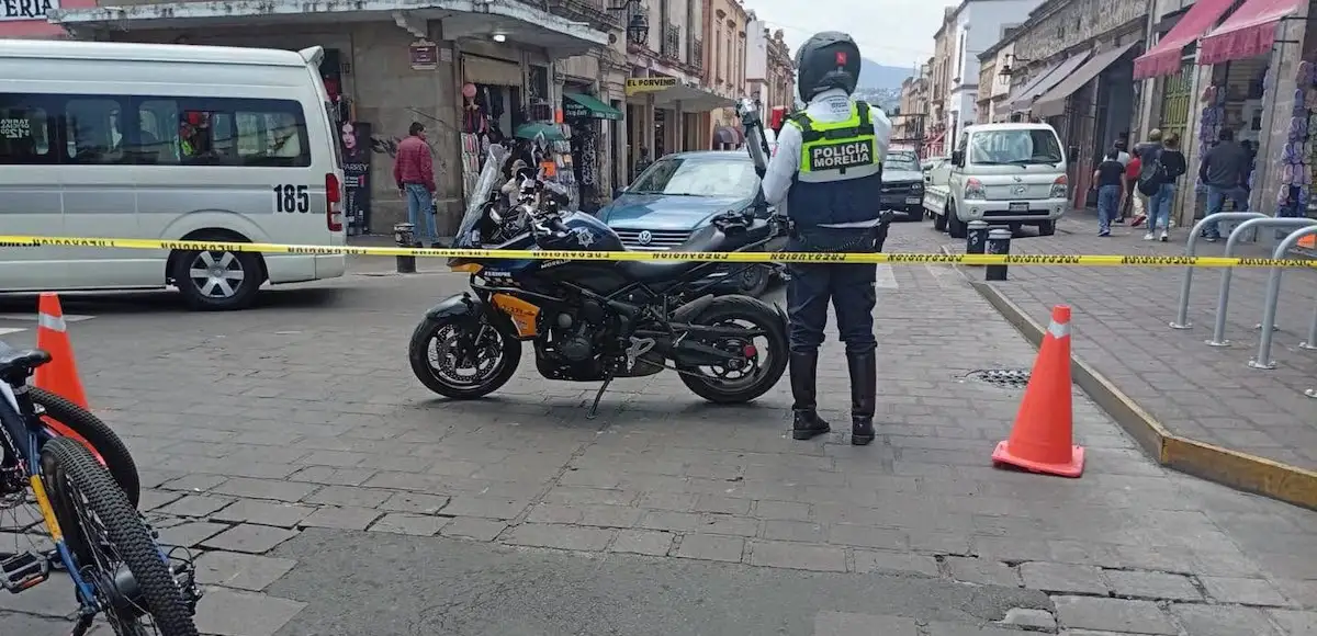 Policía municipal de Morelia junto a su motocicleta cierra la circulación vial. 