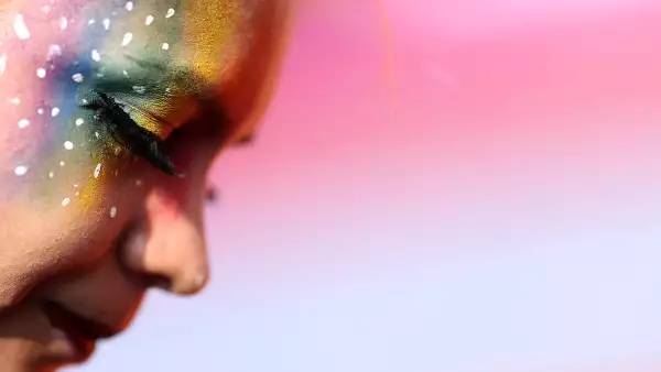 (Un asistente a la marcha del orgullo LGBT, muestra un maquillaje con los colores del arcoíris​​)