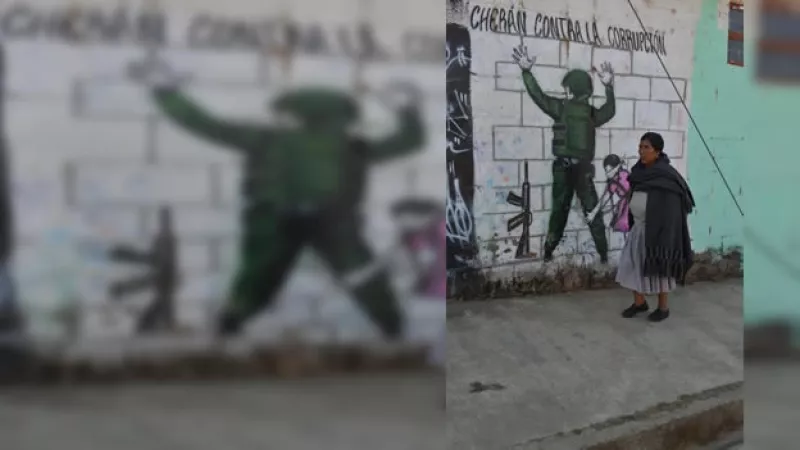 una mujer pasa junto a un mural en cheran