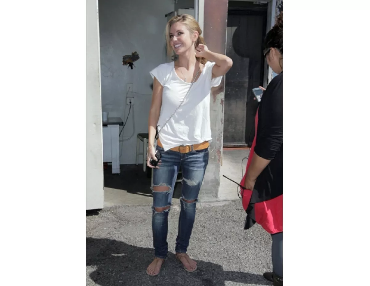 Audrina Patridge usando jeans rotos.