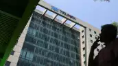 (Una persona fuma frente a un edificio corporativo de Telmex)