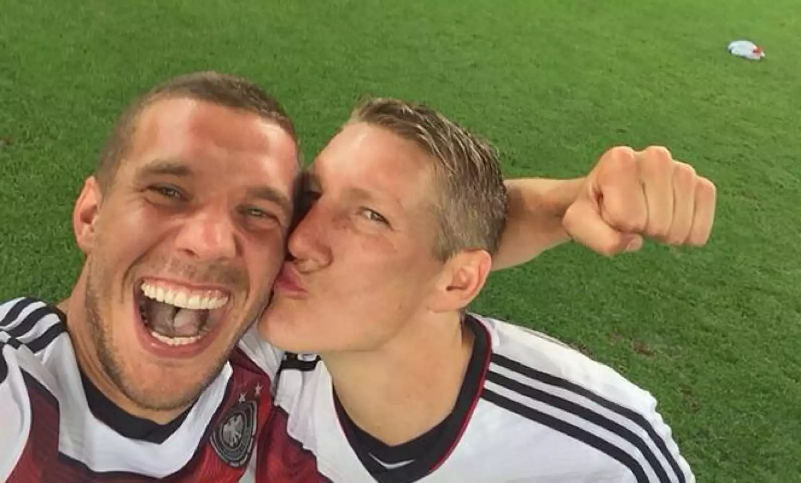 Podolski  recibe un beso de Bastian Schweinsteiger en la celebración de la Copa del Mundo.