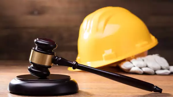 Gavel In Front Of Yellow Safety Helmet