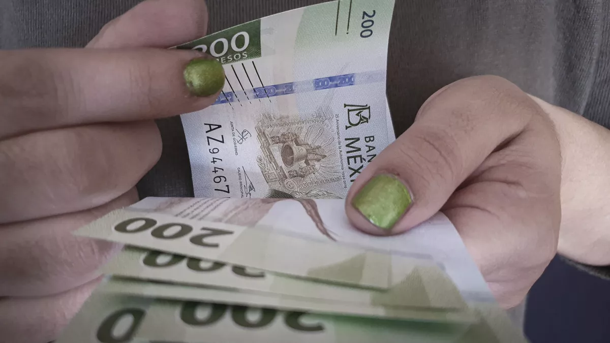 hands of a woman counting Mexican money