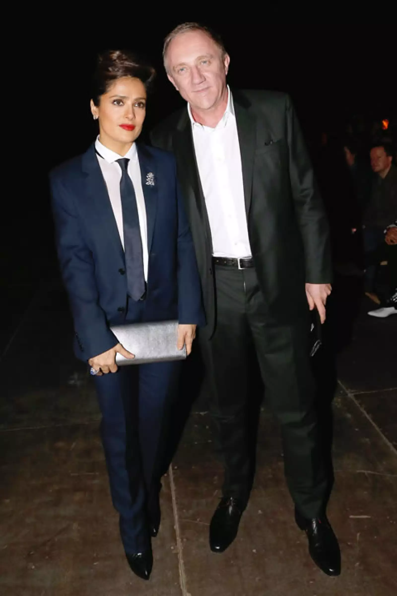Salma Hayek  se presentó al show de Saint Laurent Menswear en PFW usando un smoking de la misma marca de la colección pasada, creó un look de impacto contrastando su outfit masculino con labios rojo intenso y un chongo sesentero.