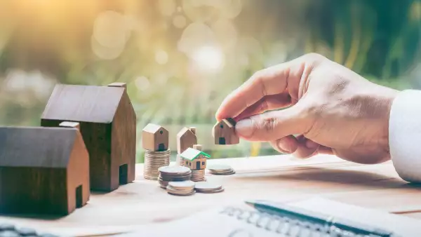 House placed on coins Men's hand is planning savings money of coins to buy a home concept concept for property ladder, mortgage and real estate investment. for saving or investment for a house,