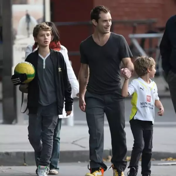 El actor Jude Law en su faceta de papá llevando a dos de sus hijos a una practica de futbol soccer en Nueva York. Curiosamente los tres se visten con el mismo estilo, jeans y tenis por fuera de los jeans.