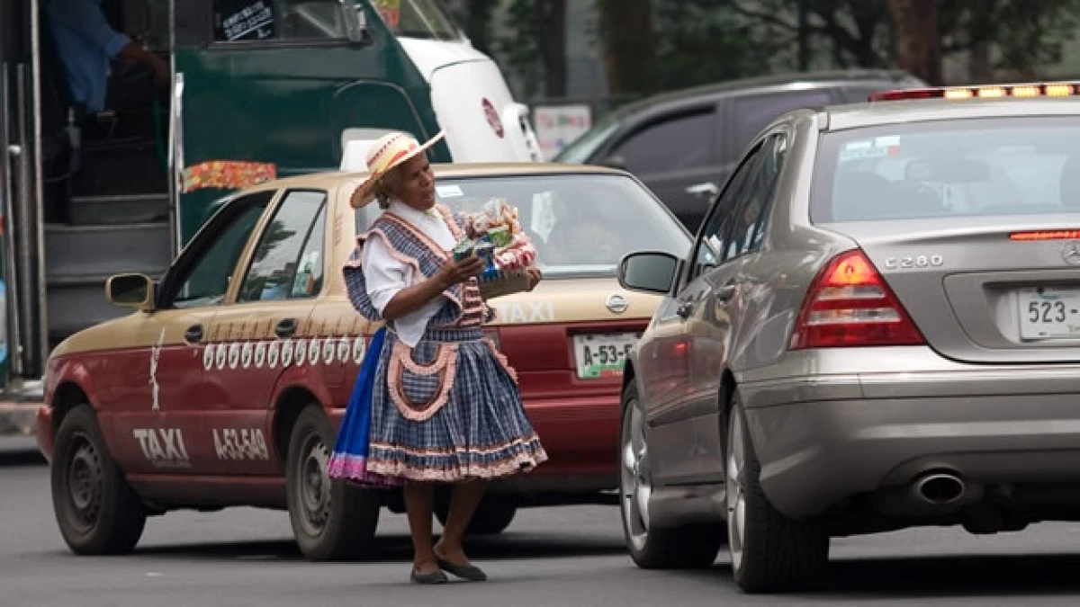 na mujer adulta, ofrece cigarros y dulces en un crucero de la ciudad, muchas de estas personas sufren discriminación y exclusión, además de tener pocas oportunidades para obtener un trabajo formal.