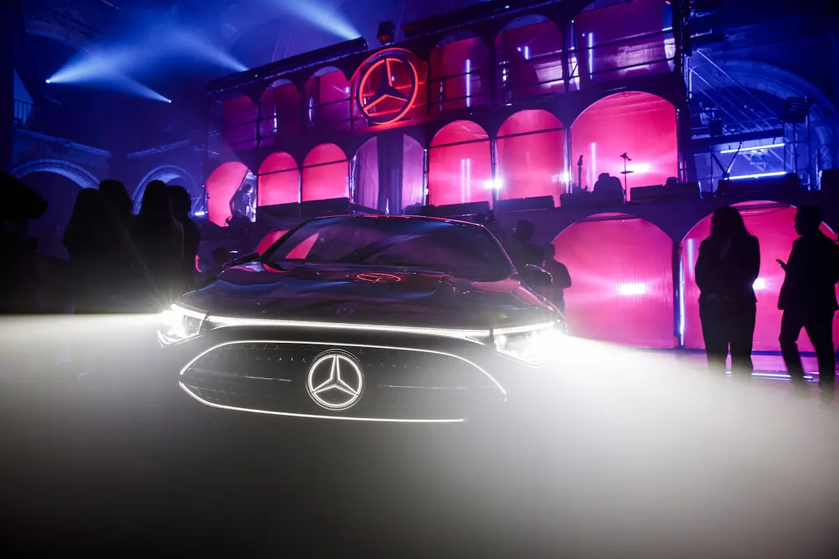 Foto frontal del nuevo CLA 2027 de Mercedes Benz luciendo su iluminación led que delinea la parte frontal y el famoso emblema de la estrella de tres puntas.