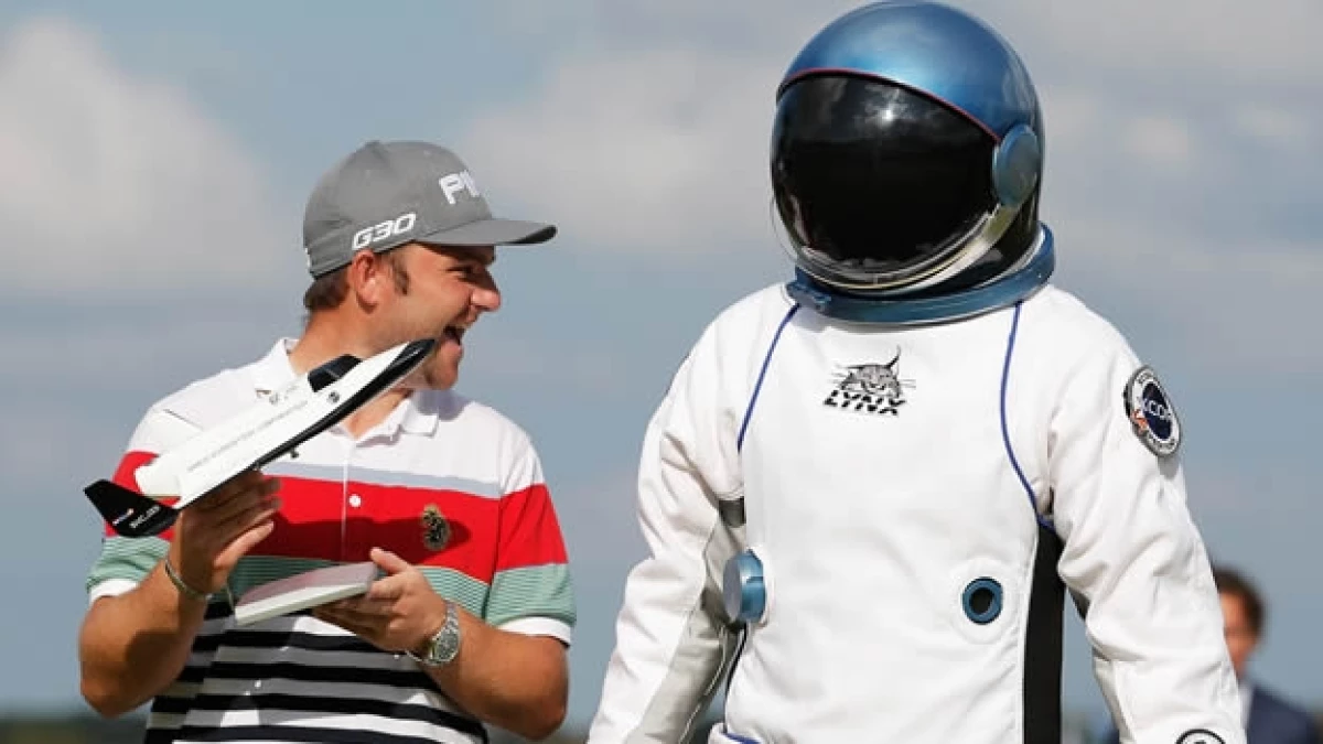El golfista inglés Andy Sullivan festeja junto a un ?astronauta? su hoyo en uno y viaje al espacio