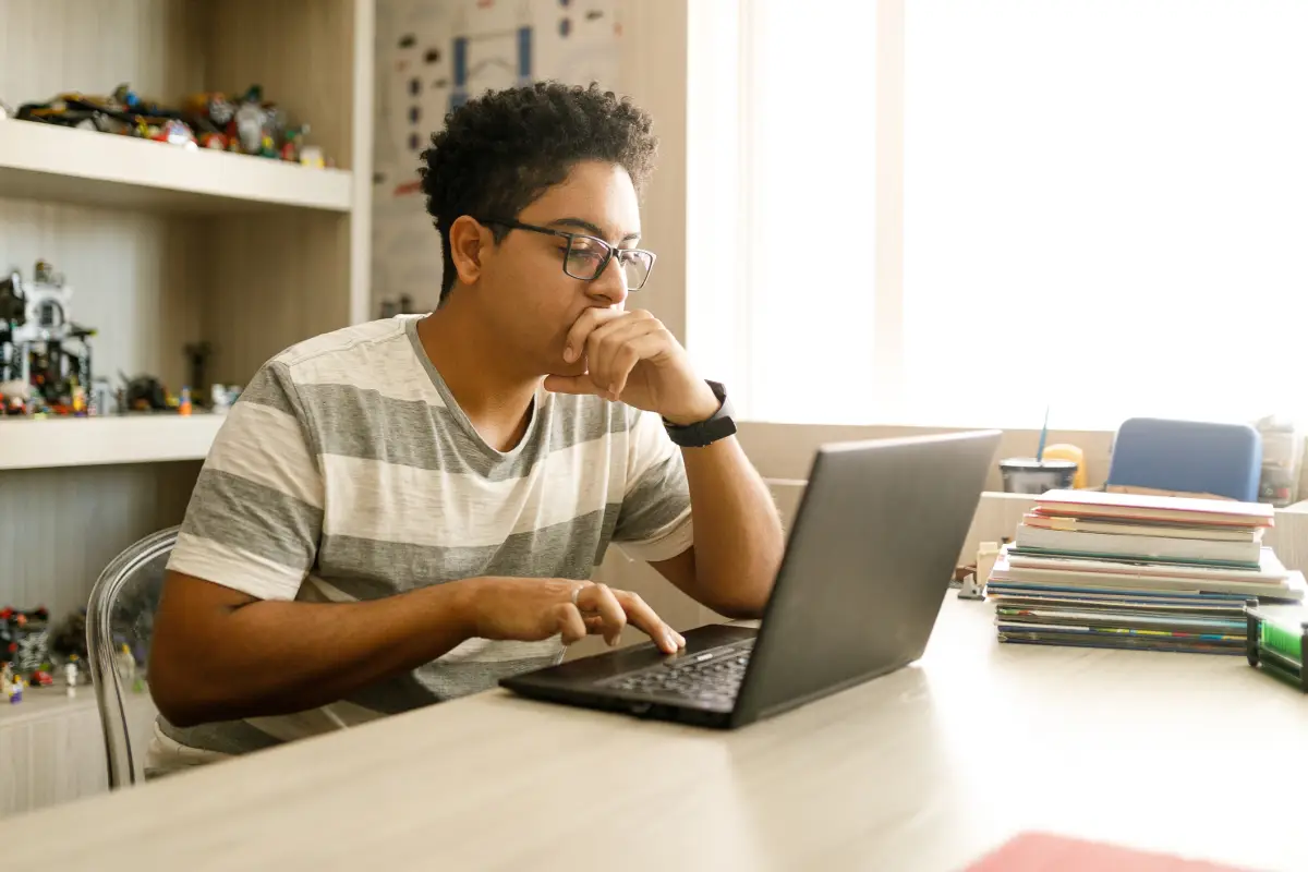 Un joven utilizando una lap top. 