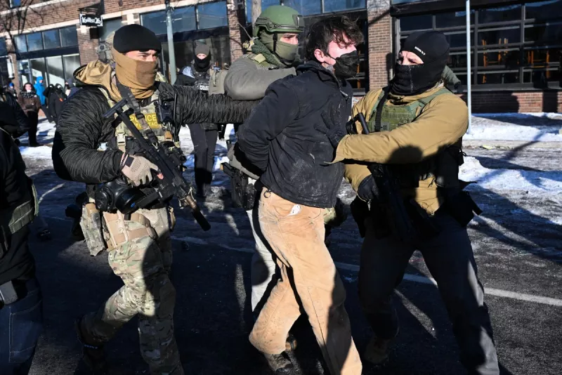 Un hombre es detenido por las fuerzas del orden, cerca del lugar donde las autoridades estatales y locales dicen que un hombre recibió un disparo por agentes federales temprano en la mañana en Minneapolis, Minnesota, el 24 de enero de 2026. El gobernador de Minnesota, Tim Walz, dijo el sábado que los agentes federales desplegados en Minneapolis como parte de una amplia represión de la inmigración habían llevado a cabo "otro tiroteo horrible", menos de tres semanas después del tiroteo fatal de Renee Good.