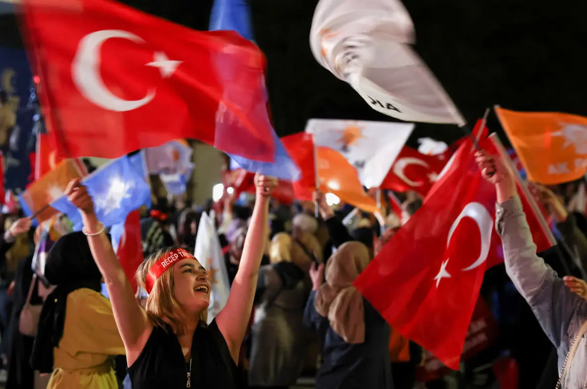 Un partidario del presidente turco, Tayyip Erdogan, ondea banderas fuera de la sede del Partido AK, en Ankara, Turquía, el 15 de mayo de 2023.