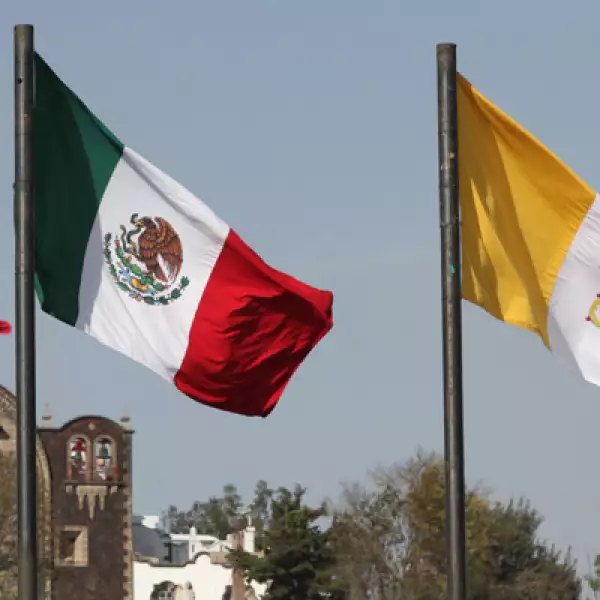 Afuera del recinto ondean las banderas de ambas naciones.