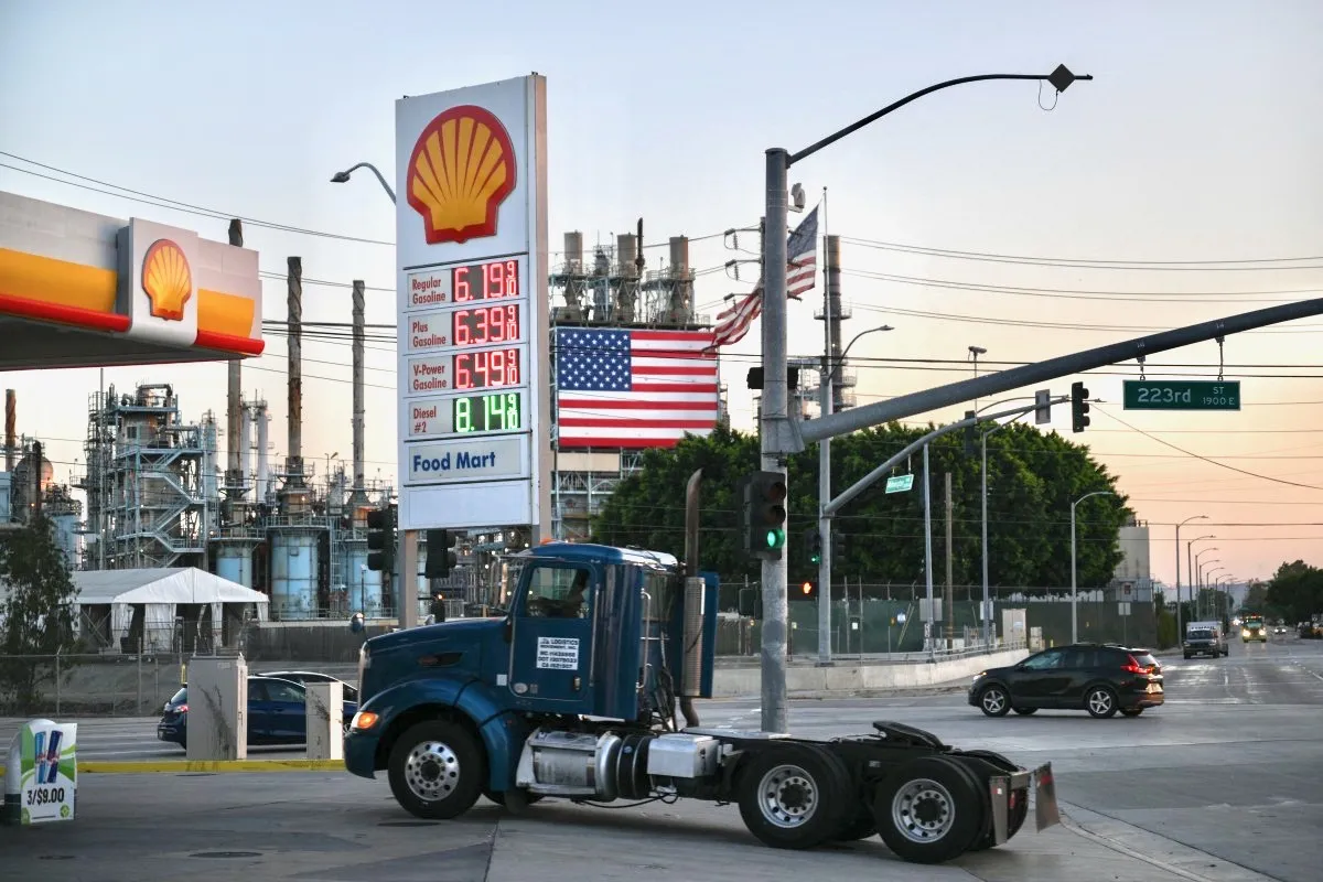 Una gasolinera Shell de Estados Unidos que muestra los precios del diésel mientras entra un tractocamión de color azul.