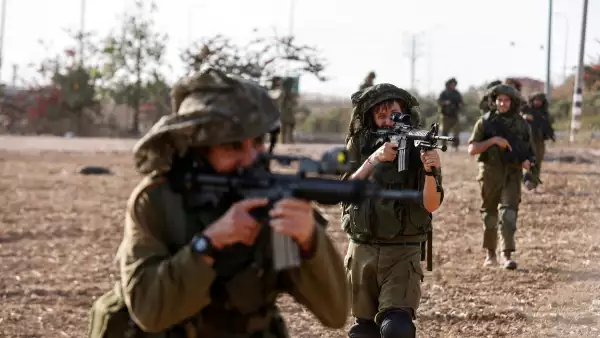 Los soldados israelíes toman posición mientras están estacionados cerca de la frontera de Israel con Gaza en el sur de Israel, el 12 de octubre de 2023.
