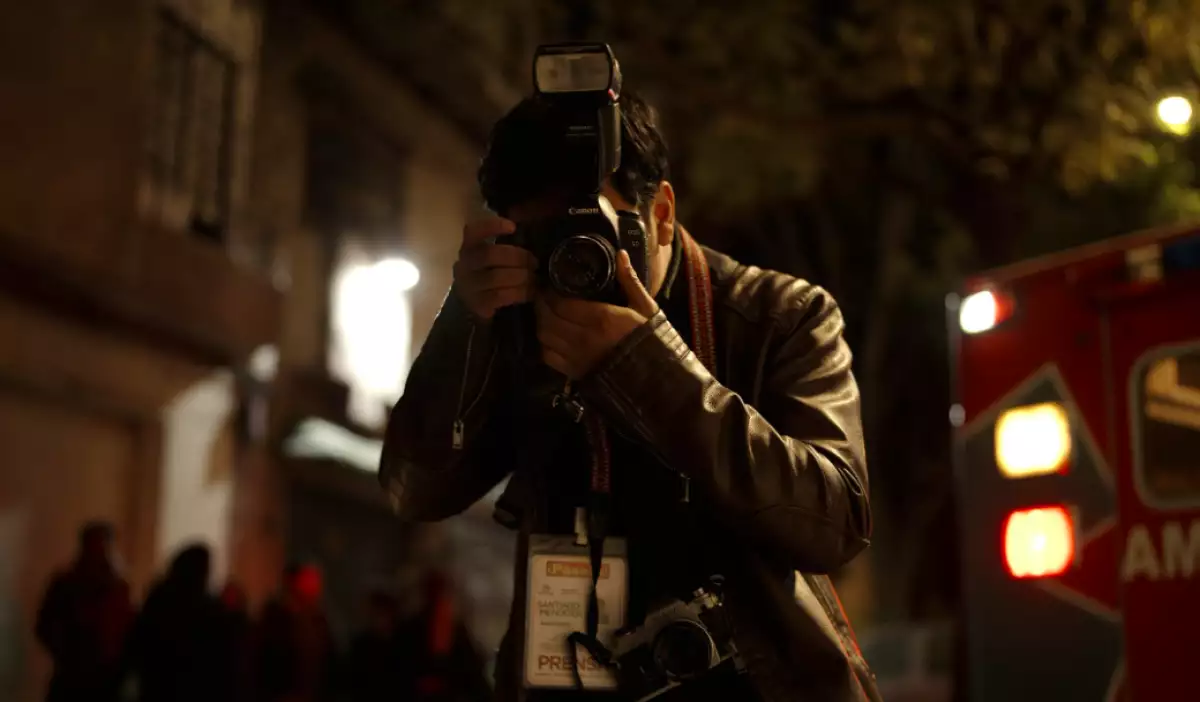 Foto de una escena de la película de terror 'Desaparecer por completo' con Santiago, el personaje principal, tomando una fotografía.
