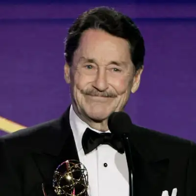 El actor Peter Cullen vestido con un esmoquin sonríe frente en una premiación