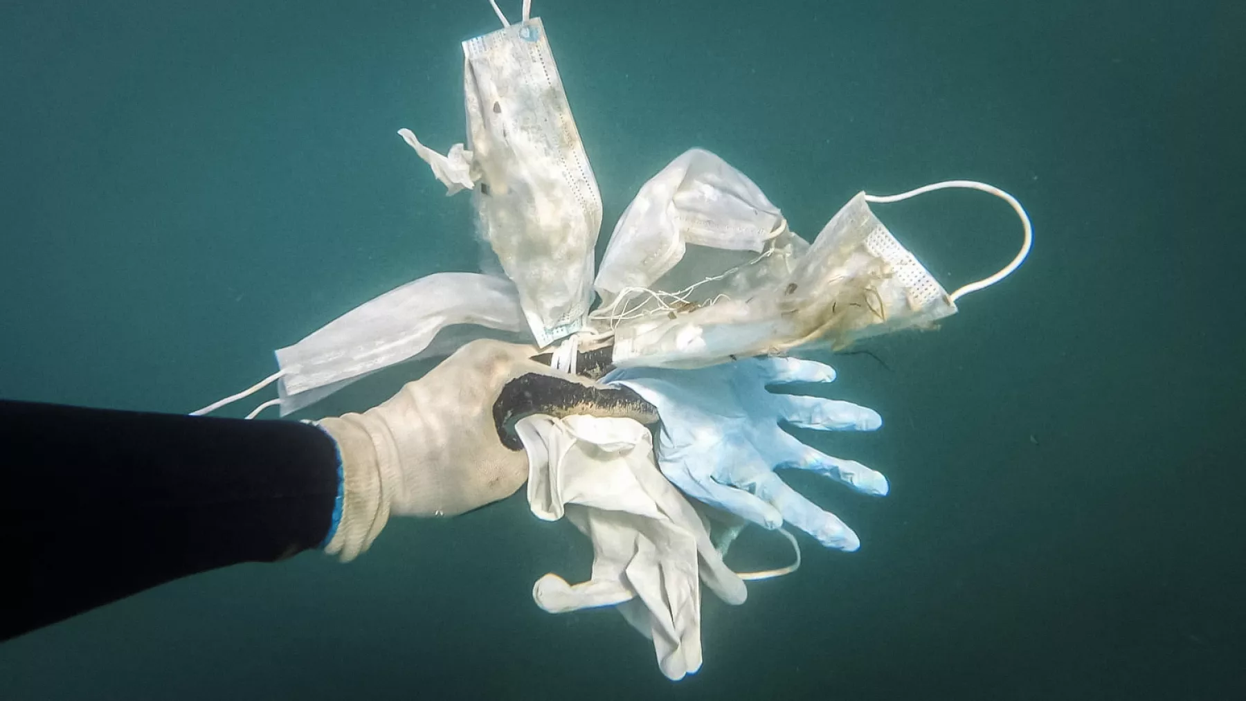 Sea clean-up volunteer diver captures photographs of masks and gloves in the Mediterranean Sea