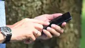 Una persona donde solo se ve su mano que está sosteniendo un teléfono para llamar
