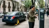 Mujer utiliza el parquímetro en la Ciudad de México para estacionar su carro en la calle.