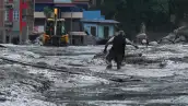 Un residente camina por una calle cubierta de barro tras unas inundaciones repentinas y un deslizamiento de tierra en Devighat, en el distrito nepalí de Nuwakot, el 26 de agosto de 2026. Los equipos de rescate se movilizaron con urgencia el 27 de agosto para localizar a cientos de personas desaparecidas en la frontera entre Nepal y el Tíbet, a causa de inundaciones repentinas y deslizamientos de tierra que causaron la muerte de al menos 160 personas y arrasaron aldeas enteras. 