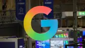 La letra G en tamaño gigante en medio de un salón. Luce en sus colores azul, naranja, verde y amarillo.jpg