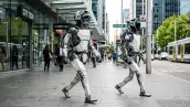 Imagen generada con IA de dos robots humanoides paseando por la calle en medio de las personas en un entorno urbano.