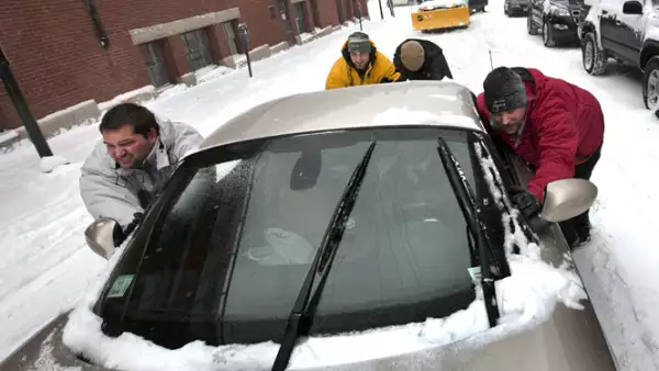 Millones de estadounidenses salieron temprano de sus trabajos por el temor a quedar varados en las carreteras. Un grupo de hombres en Portland ayuda a liberar un vehículo en la nieve.