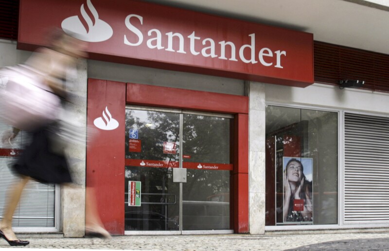 A woman walks past Santander bank branch in Rio de Janeiro
