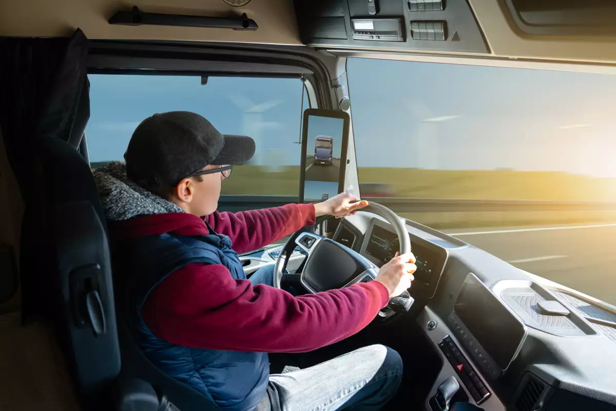 (Conductor de un tráiler maneja por una carretera)