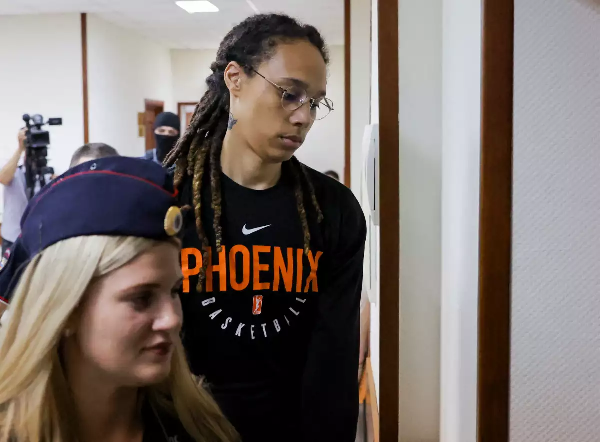 La basquetbolista estadounidense Brittney Griner es escoltada antes de una audiencia en una corte de Khimki, afuera de Moscú; la basquetbolista fue liberada hoy