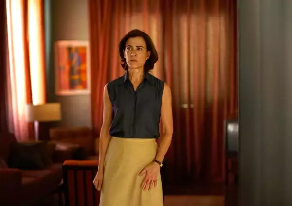 Foto de una escena de 'Aún estoy aquí', con la protagonista Fernanda Torres parada en medio de la sala de una casa.