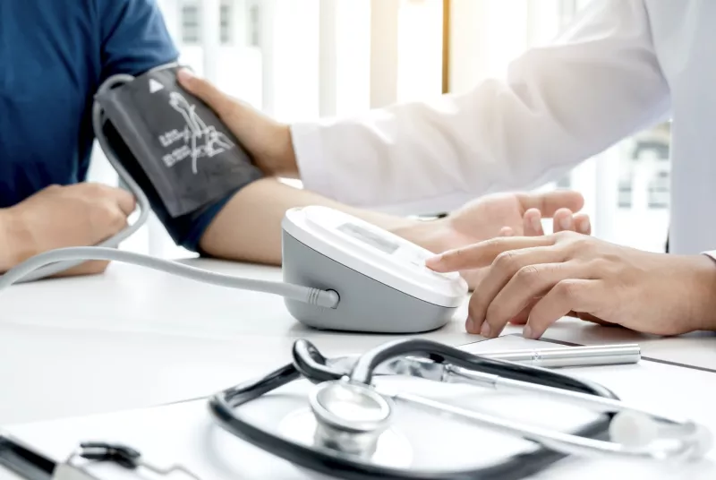 Médico tomándole la presión al colaborador de una empresa, durante la semana de la salud