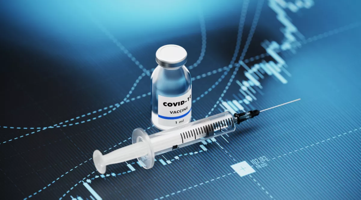 COVID-19 Vaccine and Syringe Sitting over Blue Financial Graph Background - COVID-19 Vaccine and Stock Market and Finance Concept