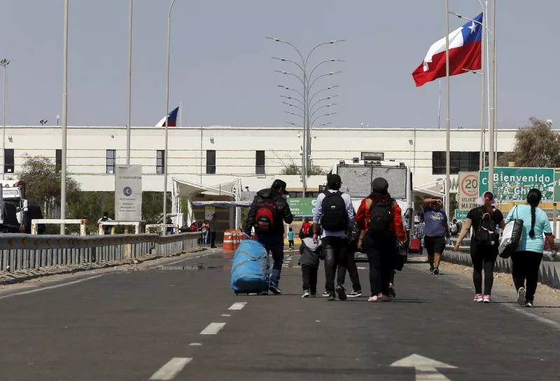 La gente camina hasta la entrada fronteriza de Chile, mientras que los migrantes indocumentados, en su mayoría de Venezuela, Colombia y Haití, permanecen atrapados en Chile, después de que Perú se negara a abrir sus fronteras a los migrantes que regresaban a sus países, según los medios de comunicación locales, en el área de Chacalluta, Arica, Chile, el 29 de abril de